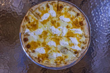 Cam zemin üzerinde izole edilmiş farklı peynirlerle pizzanın görüntüsünü kapat.