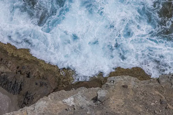 Top view of waves from Atlantic Ocean breaking against rocks of mountains. Spain.