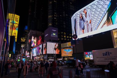 İnsanlar Broadway 'de gece vakti New York City' de gökdelenler üzerinde parıldayan LED reklam panelleri arasında geziniyor. - New York. ABD. 