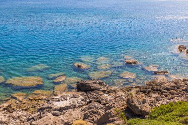 Rodos 'un kayalık Ege sahilinin nefes kesici manzarası, sıcak güneş ışığı ve kristal berrak sular tarafından öpüldü. Yunanistan.