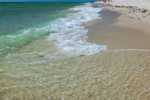 Atlantic Ocean waves roll onto sandy shores of Miami Beach.