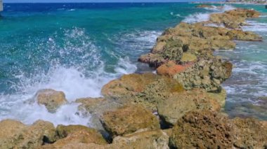 Karayip Denizi 'nin çarpıcı bir görüntüsü, Curacao adasındaki yapay bir dalganın yavaş çekim çarpışmasını yakalıyor..