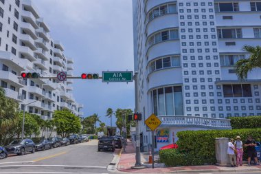 Miami Plajı 'ndaki caddelerden birinin manzarasında Collins Caddesi' nin kesiştiği yerde insanlar var. ABD. 