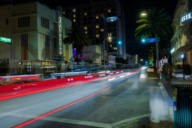 Collins Bulvarı 'ndaki arabalardan çıkan çarpıcı odaklanmış ışık yollarıyla Miami Beach' in güzel gece manzarası. Florida mı? Miami Plajı. ABD.