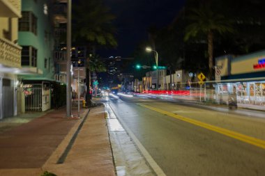 Collins Bulvarı 'ndaki arabalardan gelen çarpıcı odaklanmış ışık yollarıyla Miami Plajı' nın gece manzarası. Florida mı? Miami Plajı. ABD.