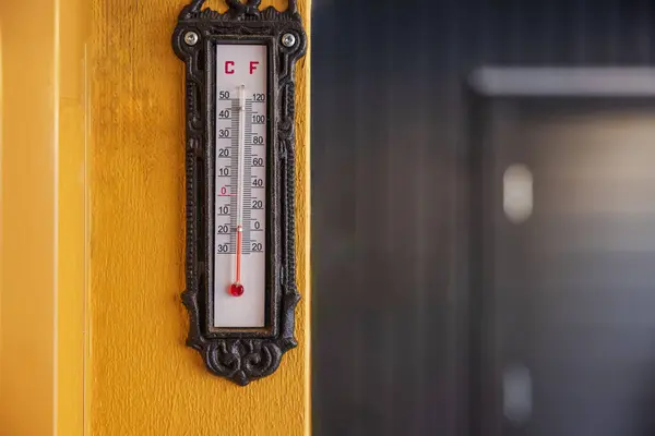 Close-up view of outdoor thermometer displaying subzero ambient temperature, attached to door frame at entrance of villa. Sweden.
