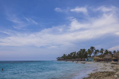 Karayip Denizi 'ndeki Kartal Sahili' nin güzel manzarası. İnsanlar kumsaldaki şezlonglarda dinleniyor. Aruba.