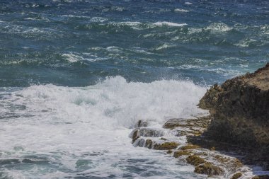 Karayip Denizi 'nin güzel manzarası Aruba' nın kayalık kıyı şeridine çarpıyor..