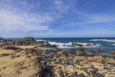 Karayip Denizi dalgalarının kayalara çarptığı Aruba 'nın kayalık kıyı şeridinin manzarası..