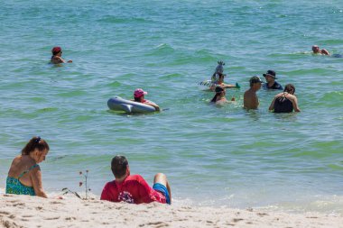 Miami Sahili 'nin büyüleyici kıyıları boyunca Atlantik Okyanusu' nun masmavi sularında yüzen insanların görüntüsü. ABD.