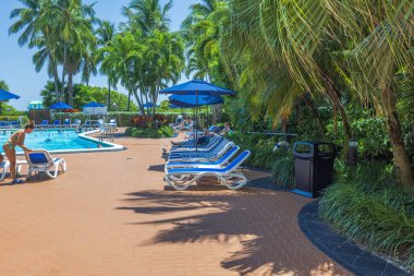 Otelin güzel manzarası, misafirlerin şemsiyelerin altında dinlendiği açık havuz manzarası. Miami Plajı. ABD.