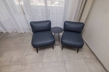 Bir otel odasının köşesinde aralarında masa olan iki sandalyenin güzel iç manzarası. Curacao.