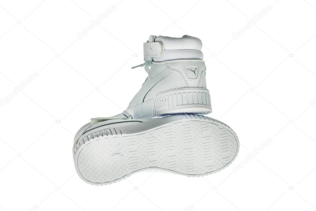 Close-up view of high-top white Puma sneakers on white background.