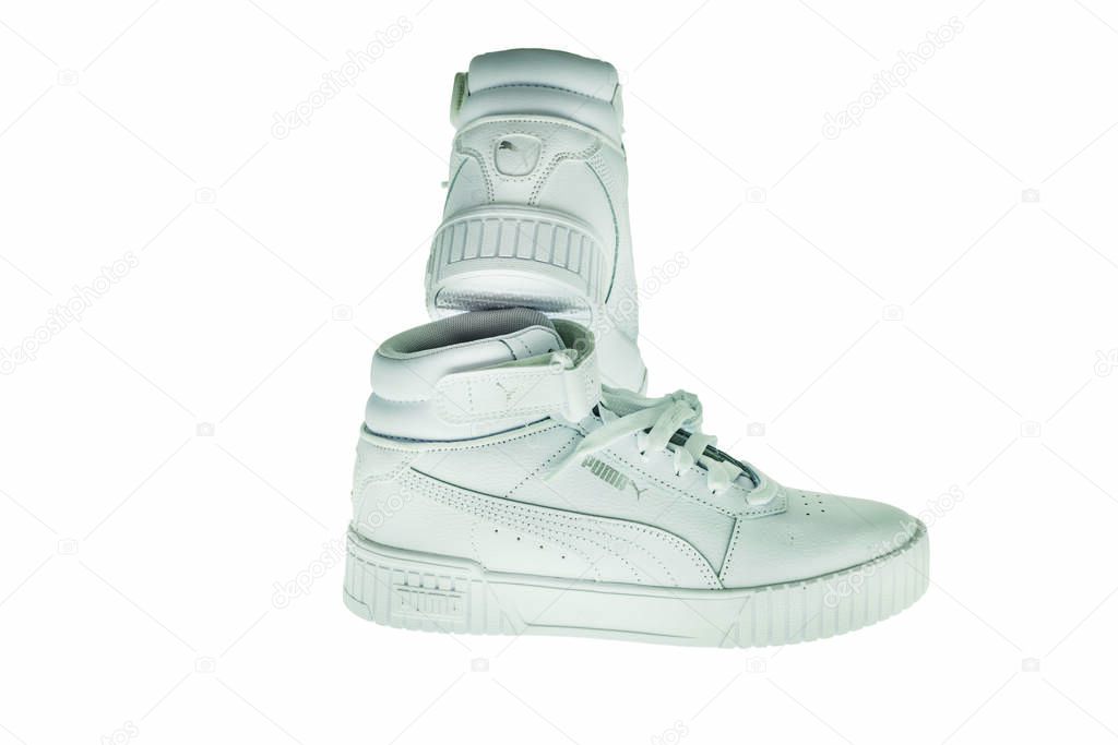 Close-up view of high-top white Puma sneakers isolated on white background.
