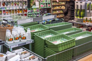 Bahçe ve bahçe için plastik bitki tepsileri ve diğer eşyalar ile bahçe manzarası. 