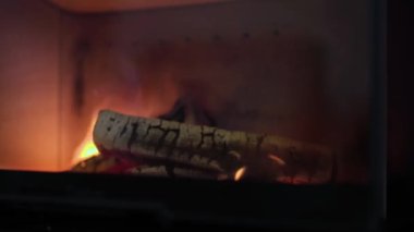 Huş ağacını yakan bir evde şöminenin yakın görüntüsü bir akşam için sıcak ve samimi bir atmosfer yaratıyor. İsveç.