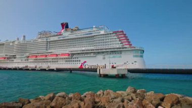 Karayip Denizi 'ndeki Curacao limanında demirlemiş bir yolcu gemisini yakalayan kumlu bir sahilden güzel bir manzara.