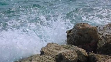 Karayip Denizi dalgalarının doğal kayalara çarpmasının büyüleyici yavaş çekim görüntüleri. Curacao.