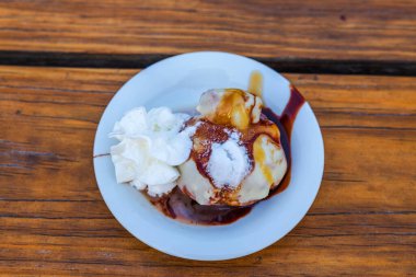 Çikolata ve portakal şurubuyla serpiştirilmiş bir tabakta çeşitli dondurma aromalarının yakın plan görüntüsü. Curacao.