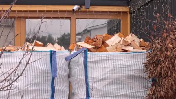 在别墅前面的人行道上放着装有桦树木柴的托盘上的运输包 — 图库视频影像