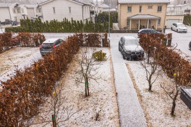 Topluluktaki villalarda kar yağışı ortasında güzel bir bahar sahnesi. İsveç.