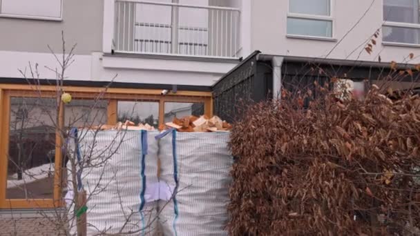 ヴィラの外側の歩道に置かれたパレットの輸送バッグにバーチの薪を配置しました スウェーデン — ストック動画