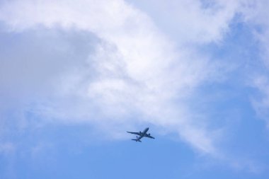 Beyaz bulutlu mavi gökyüzünün arka planına inen uçak. ABD.