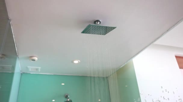 一个豪华酒店浴室的景观 设有一个大的天花板安装的雨水淋浴器 额外的墙壁安装的淋浴器 凹凸的聚光灯和透明的玻璃外壳 — 图库视频影像