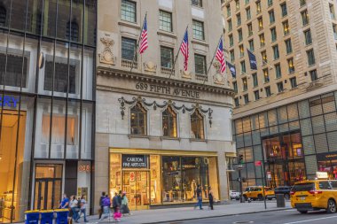 Beşinci Cadde 'nin güzel manzarası gökdelenlerin duvarlarını süsleyen Amerikan bayrakları ve cadde boyunca yürüyen insanlar. - New York. ABD. 
