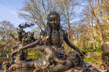 Lewis Carroll 'ın klasiğinden karakterleri resmeden Alice Harikalar Diyarında anıtının yakından görüntüsü. Arka planda bahar parkı ağaçları var. - New York. ABD.