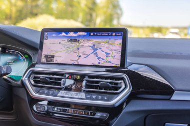 Otoyolda giderken BMW iX3 'ün rotasını gösteren navigasyon panelinin yakın görüntüsü. 