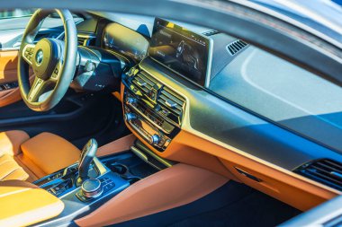 Turuncu deri koltuklu BMW i4 elektrikli arabanın yolcu tarafındaki yakın çekim görüntüsü.. 