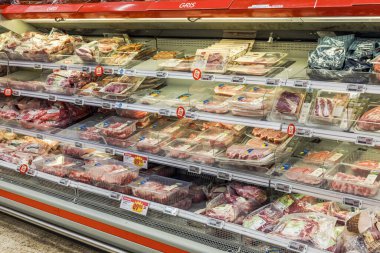 Bir marketin soğutulmuş bölümünde paketlenmiş et ürünlerinin geniş görünümü. 