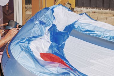 Villa avlusunda havuzu şişirmek için elektrikli hava pompası kullanan bir kadının ellerine yakından bakın. İsveç.