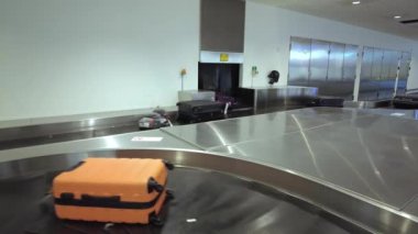 Havaalanındaki bagaj atlıkarıncasında, yolcuların vardıklarında bagajlarını alacakları yerde..