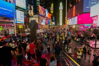 Manhattan 'daki Times Meydanı' nın Red Steps 'inden göz kamaştırıcı bir gece manzarası, gökdelen cephelerindeki parlak reklam panolarının arasında yürüyen insanlar. - New York. ABD.