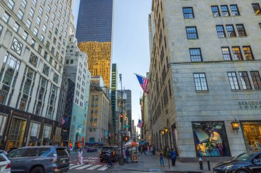 Beşinci Cadde 'nin güzel akşam manzarası yaya geçidi ve insanlar gökdelenlerin arka planına karşı caddeyi geçiyorlar. - New York. ABD. 