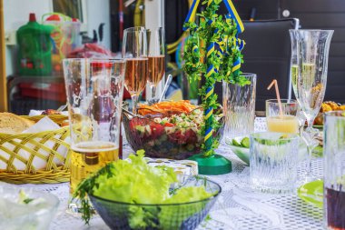 Alkollü içecekler içtikten sonra arta kalan yemekler ve boş bardaklarla şenlik masasının yakın görüntüsü. İsveç.