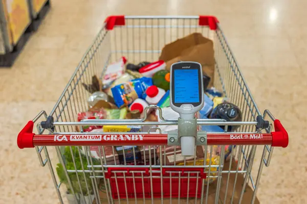 Stock image View of shopping cart loaded with groceries and barcode scanner in grocery store.