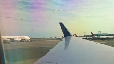 Pistte taksicilik yapan bir uçağın penceresinden diğer Delta ve Emirates uçaklarına bakan güzel bir manzara. Miami mi? ABD.