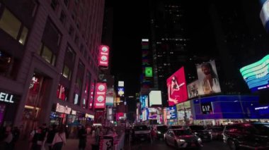 Manhattan 'da Broadway' in güzel gece manzarası, geçen araçlar, arka planda gökdelenler ve ön cephelerde aydınlatılmış reklam panoları. - New York. ABD.