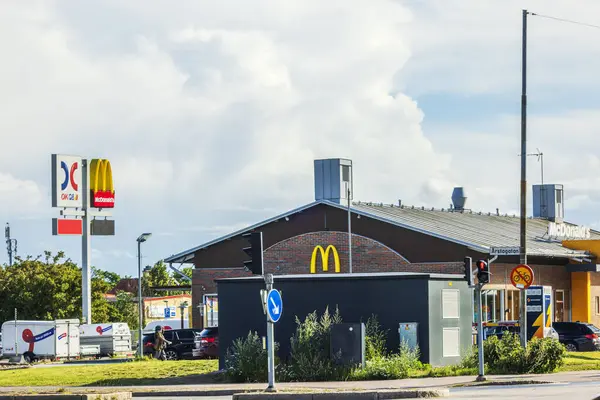 stock image McDonald's restaurant and OKQ8 gas station at intersection with traffic lights on cloudy day. 