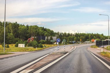 Ormanlarla çevrili güzel bir otoyol manzarası ve diğer tarafta yüksek ses engeli, doğayı modern altyapıyla harmanlıyor. İsveç.