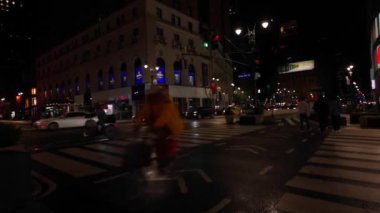 Manhattan 'daki 34. Batı Caddesi' nin gece manzarası çok güzel. Yoldan geçen arabalar ve kaldırımlarda yürüyen insanlar ıslak kaldırımları yansıtıyor. - New York. ABD. 