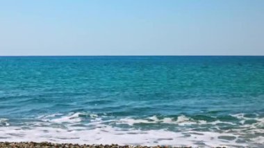 Akdeniz 'in mavi sularının güzel manzarası Girit' teki çakıl taşlı plajlara hafifçe vuran dalgalar..