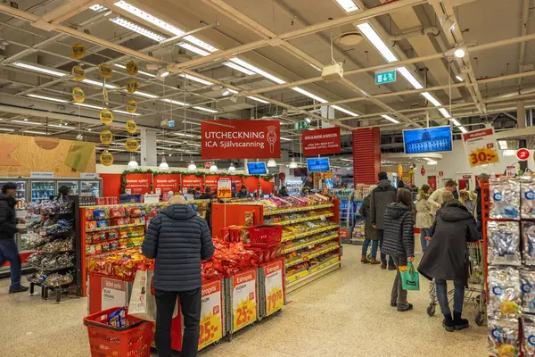 Alışverişçileri, alımları için hem geleneksel hem de self-servis kontrollerini kullanarak hipermarket çıkışlarını dolduruyorlar.. 