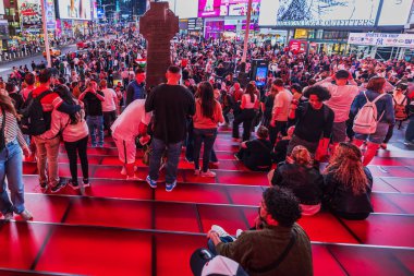 Akşamları Times Meydanı 'ndaki Kızıl Merdivenler' de büyük kalabalıklar toplanıyor. İnsanlar rahatlıyor ve manzaranın tadını çıkarıyor. - New York. ABD. 