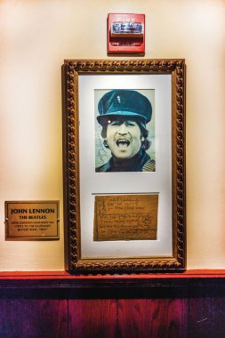 The Beatles 'tan John Lennon' ın çerçeveli fotoğrafı ve Manhattan 'daki Hard Rock Cafe Müzesi' nin duvarında el yazısıyla sergilenen notu. - New York. ABD.