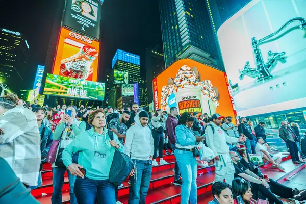 stock image People on  iconic Red Steps at Times Square, Enjoying Nightlife with LED panels on surrounding skyscrapers illuminated in background. New York. USA. 