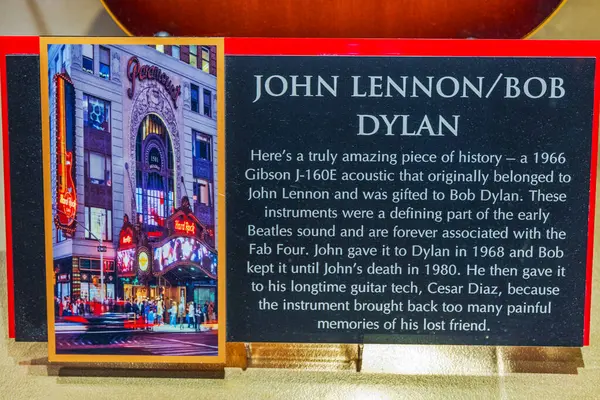 stock image Close-up of plaque beneath John Lennon and Bob Dylan guitar at Hard Rock Cafe in Manhattan, with plaque detailing history of 1966 Gibson G-160E Acoustic. New York. USA. 